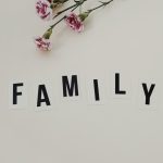 Elegant arrangement of pink flowers and family text on a white background, ideal for family themes.